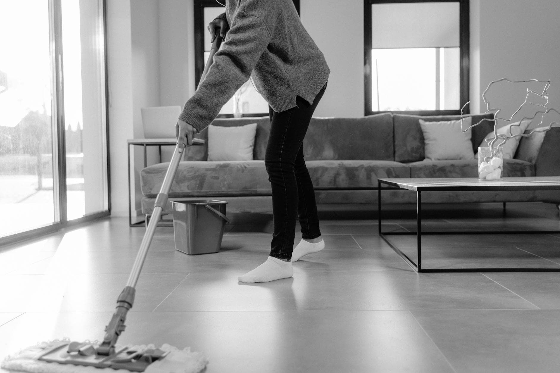 Professional Westchester cleaner mopping the floor in a modern apartment living room — Regular Apartment Cleaning in Mount Vernon, Westchester County